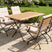 MINT Outdoor Garden Dining Set with Wooden Table and Four Comfortable Chairs in a Scenic Garden