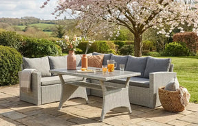 MINT Outdoor Dining and Lounge Set featuring a grey sofa and table in a garden setting