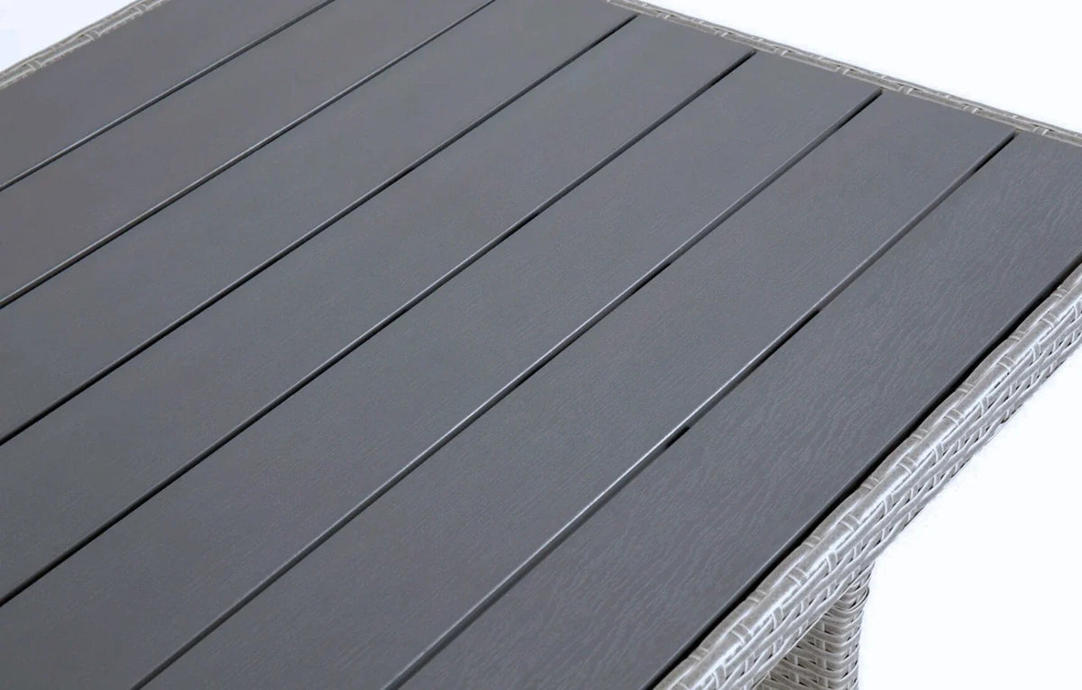 Close-up of MINT Outdoor dining set table with sleek grey slatted surface and woven rattan details