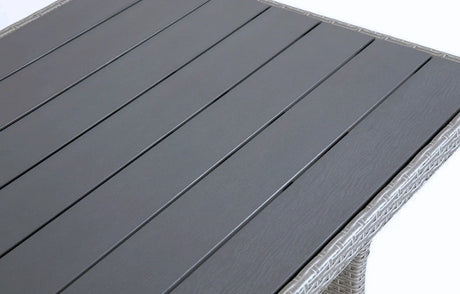 Close-up of MINT Outdoor dining set table with sleek grey slatted surface and woven rattan details