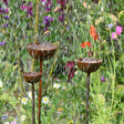 SavageWorksUK Rain Catcher in three tiers with water flowing, surrounded by vibrant flowers