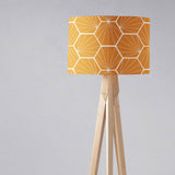 Shadow bright geometric yellow lampshade on a wooden floor lamp for stylish interior lighting