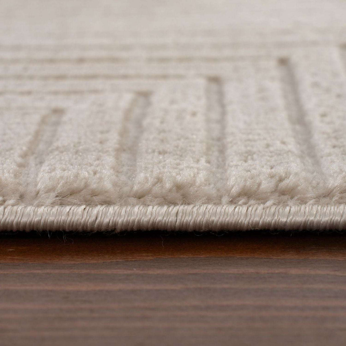 Close-up of a textured Geometric Rug with subtle patterns and a soft beige colour