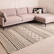 Orsina Geometric Rug in neutral tones placed under a modern sofa in a stylish living room