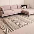 Orsina Geometric Rug in neutral tones placed under a modern sofa in a stylish living room