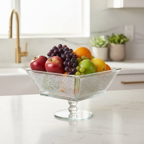 Elegant glass fruit bowl filled with vibrant apples, grapes, oranges, and pears for home decor