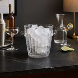 Orsina Glass Ice Bucket filled with Ice Cubes on a Dark Table with Cocktail Accessories
