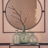 Orsina Glass Vase trio in green with decorative branches against a stylish mirror backdrop