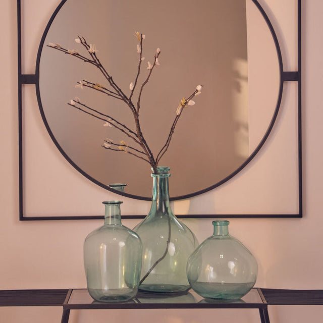 Orsina Glass Vase trio in green with decorative branches against a stylish mirror backdrop