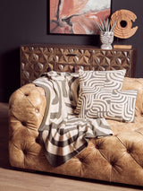 Orsina Green Throw draped over a vintage leather sofa, creating a stylish and cozy home decor