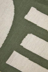 Close-up of an Orsina Green Throw featuring a modern design with neutral accents