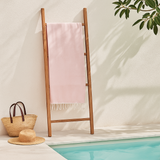 Orsina Hammam Towel in soft pink displayed on a wooden ladder near a pool