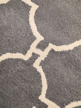 Orsina Hand Woven Rug featuring a grey background with a decorative cream pattern