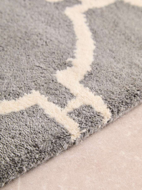 Close-up of an Orsina Hand Woven Rug in grey with cream geometric patterns