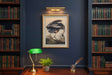 Heron On Linen Artwork elegantly framed in a library with books, table lamp, and desk decor