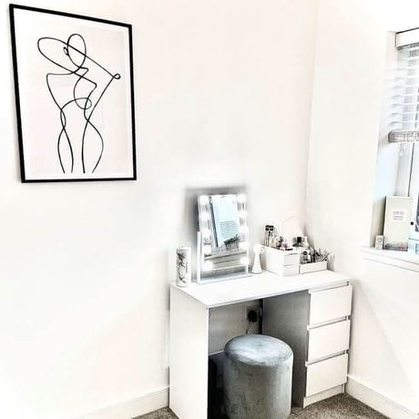 Stylish Hollywood Mirror on a modern vanity unit with beauty products in a bright room
