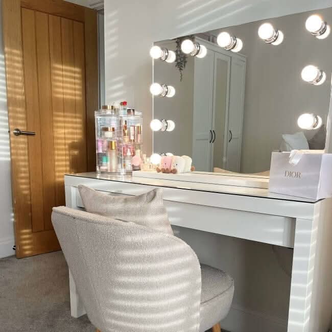 Hollywood Mirror with Bright LED Bulbs above a Stylish Vanity Table and Plush Chair