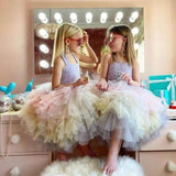 Two girls in colourful dresses admiring themselves in a Hollywood Mirror with bright lights