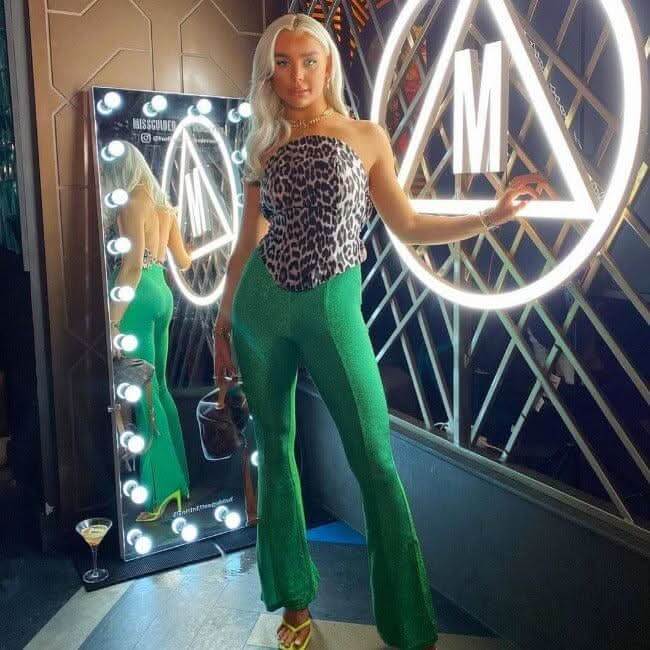 Stylish woman posing in front of a Hollywood Mirror with bright lights and modern decor
