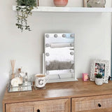 Small Hollywood Mirror with Bright Bulbs on a Dressing Table for Elegant Makeup Application