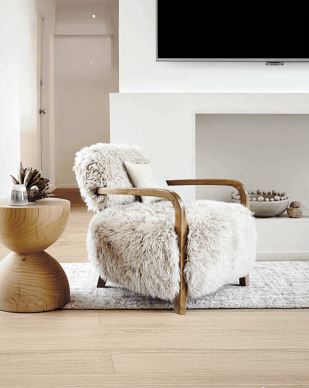 Luxurious Nisu Home armchair with soft fur upholstery and wooden armrests in a modern living room