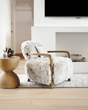 Luxurious Nisu Home armchair with soft fur upholstery and wooden armrests in a modern living room