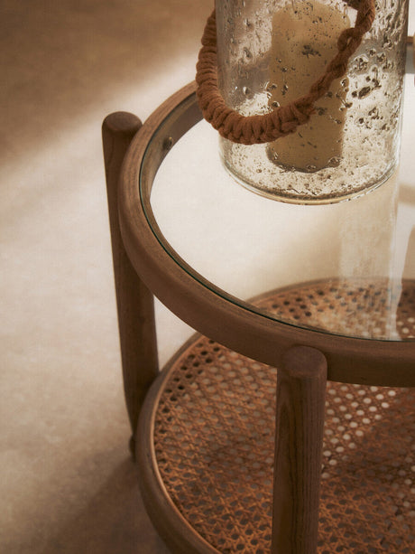 Orsina Side Table with a glass top and woven rattan base for a stylish accent in any room