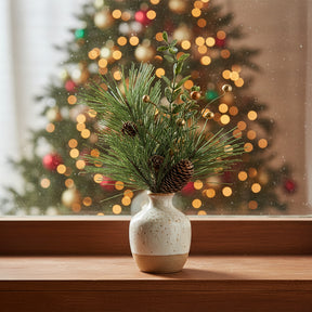 Festive arrangement of artificial greenery in a vase with gold spray accents for Christmas decor