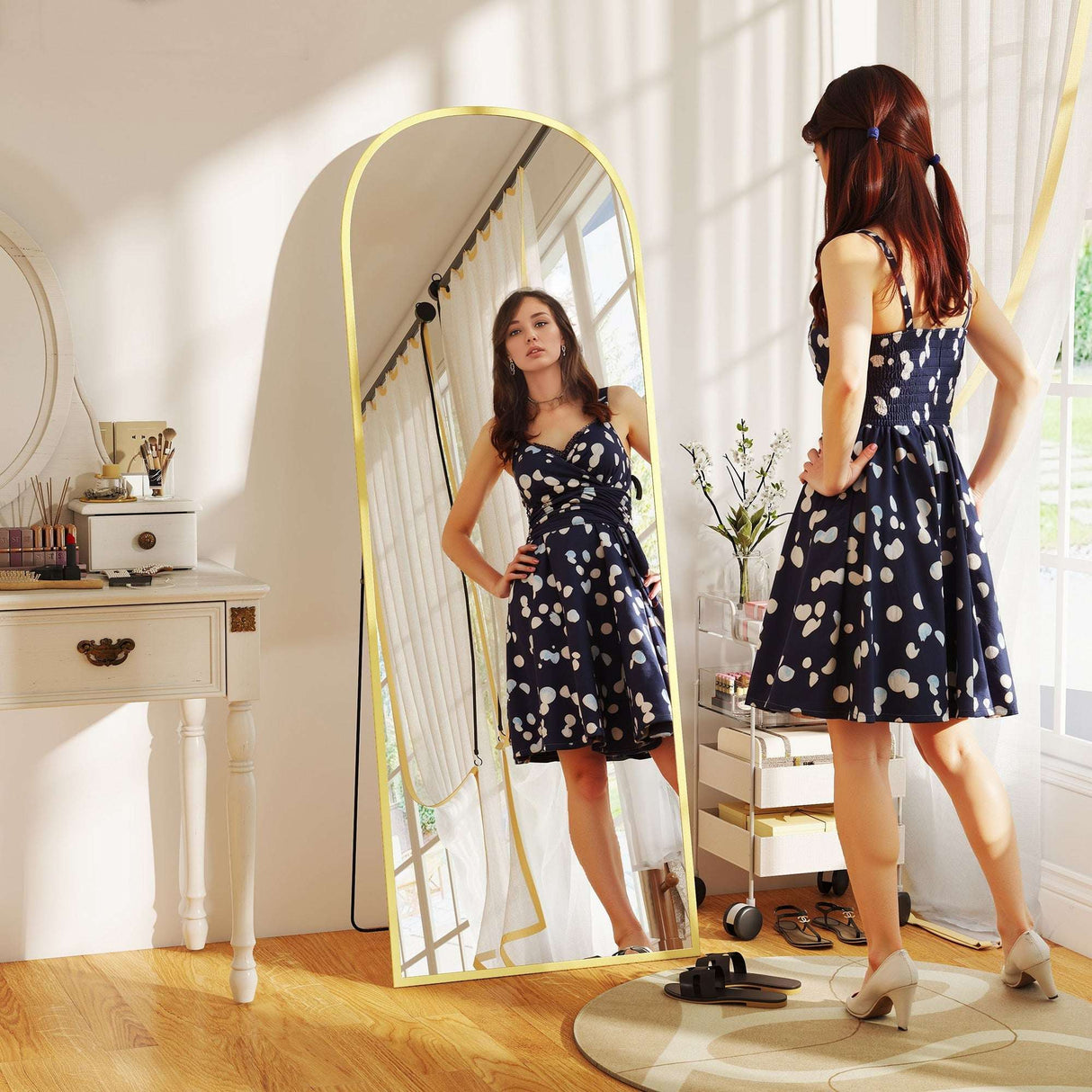 Elegant Standing Mirror in a bright room reflecting a woman in a polka dot dress