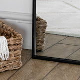 Jobu Home Arch Mirror with a sleek black frame reflecting a stylish woven basket