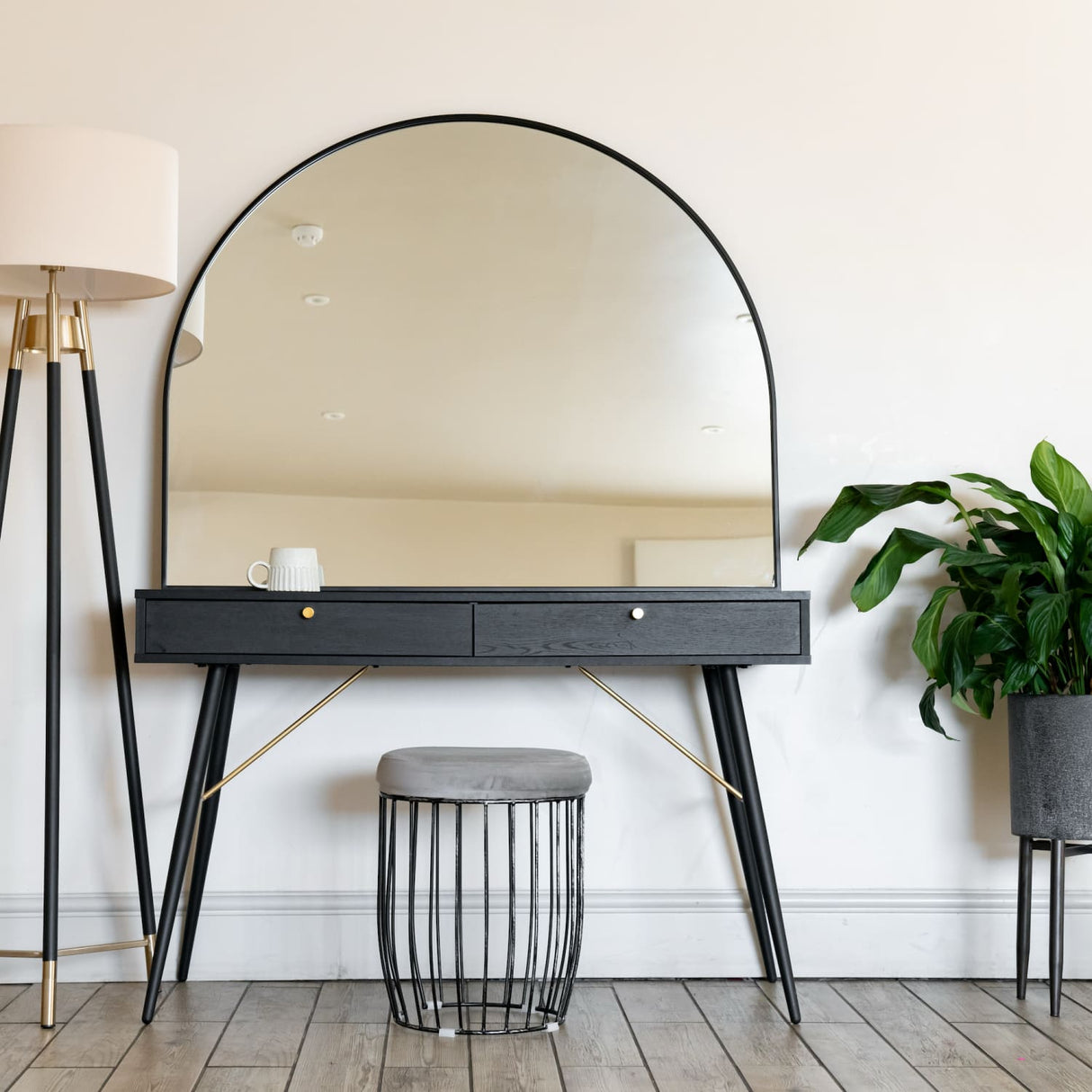 Jobu Home Arched Mirror with a sleek black frame above a stylish vanity table and potted plant