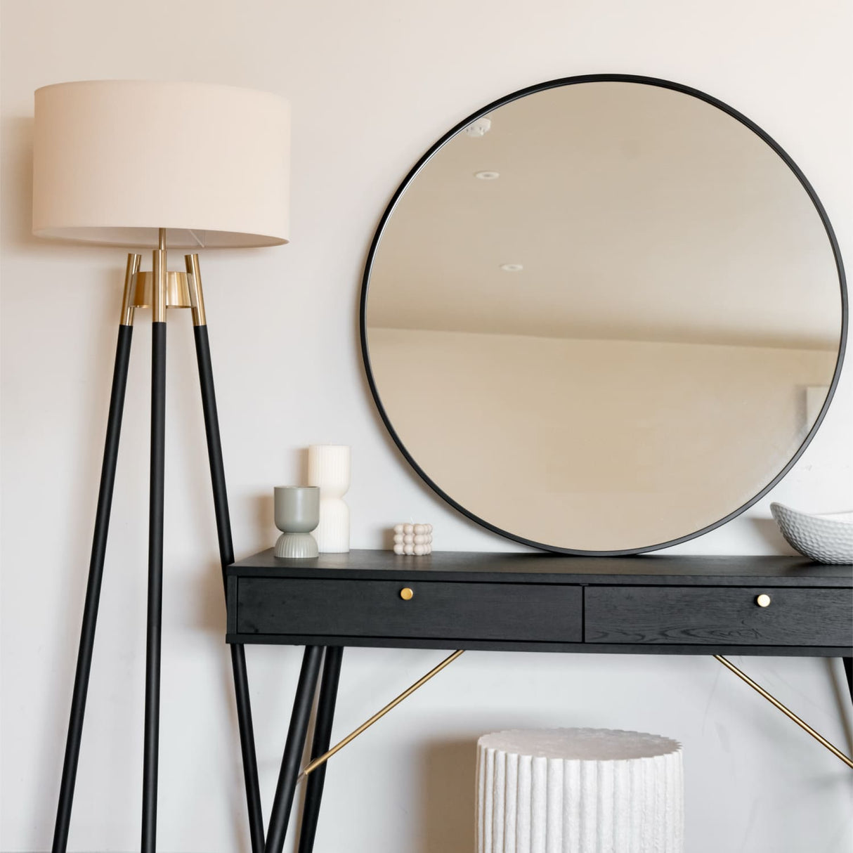 Elegant Circle Mirror above a sleek black console table with stylish decor and a lamp
