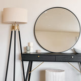 Elegant Circle Mirror above a sleek black console table with stylish decor and a lamp