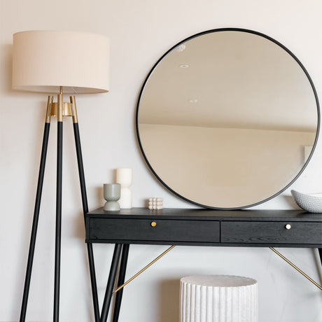 Elegant Circle Mirror above a sleek black console table with stylish decor and a lamp