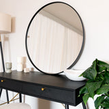 Elegant Circle Mirror above a stylish black desk with modern decor and green plants