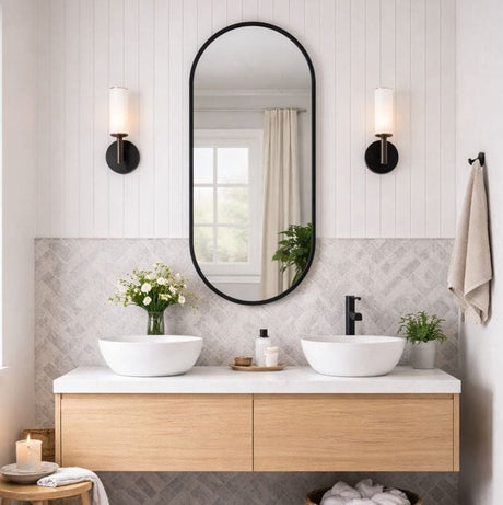 Elegant oval mirror above double sinks in a modern bathroom with stylish decor