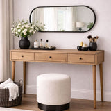 Jobu Home Oval Mirror above a wooden console table decorated with flowers and accessories