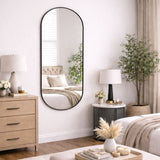 Jobu Home Oval Mirror in a stylish black frame reflecting a modern bedroom decor