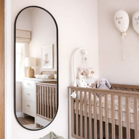 Jobu Home Oval Mirror with a sleek black frame, perfect for modern nursery decor