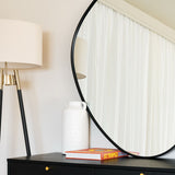 Jobu Home Pebble Mirror in round shape with stylish lamp and decor on a sleek black table