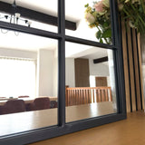 Jobu Home Window Mirror with a modern frame reflecting a bright dining area and flowers