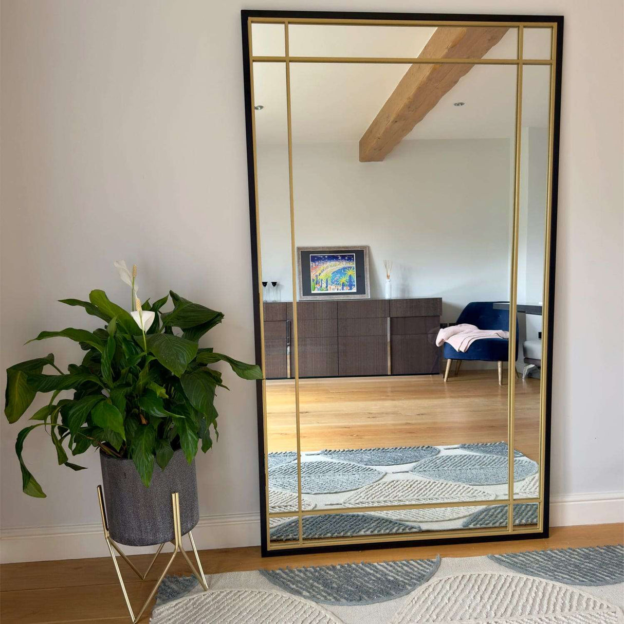 Jobu Home Window Mirror with a sleek black frame and elegant gold detailing in a modern living space