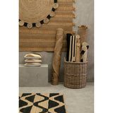 Orsina Jute Rug displayed with decorative rolls and cushions in a modern interior setting