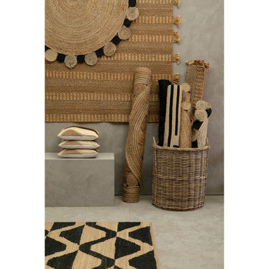 Orsina Jute Rug displayed with decorative rolls and cushions in a modern interior setting