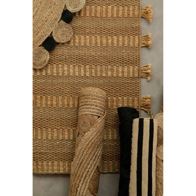 Orsina Jute Rug featuring a textured design with tassels and rolled-up striped patterns