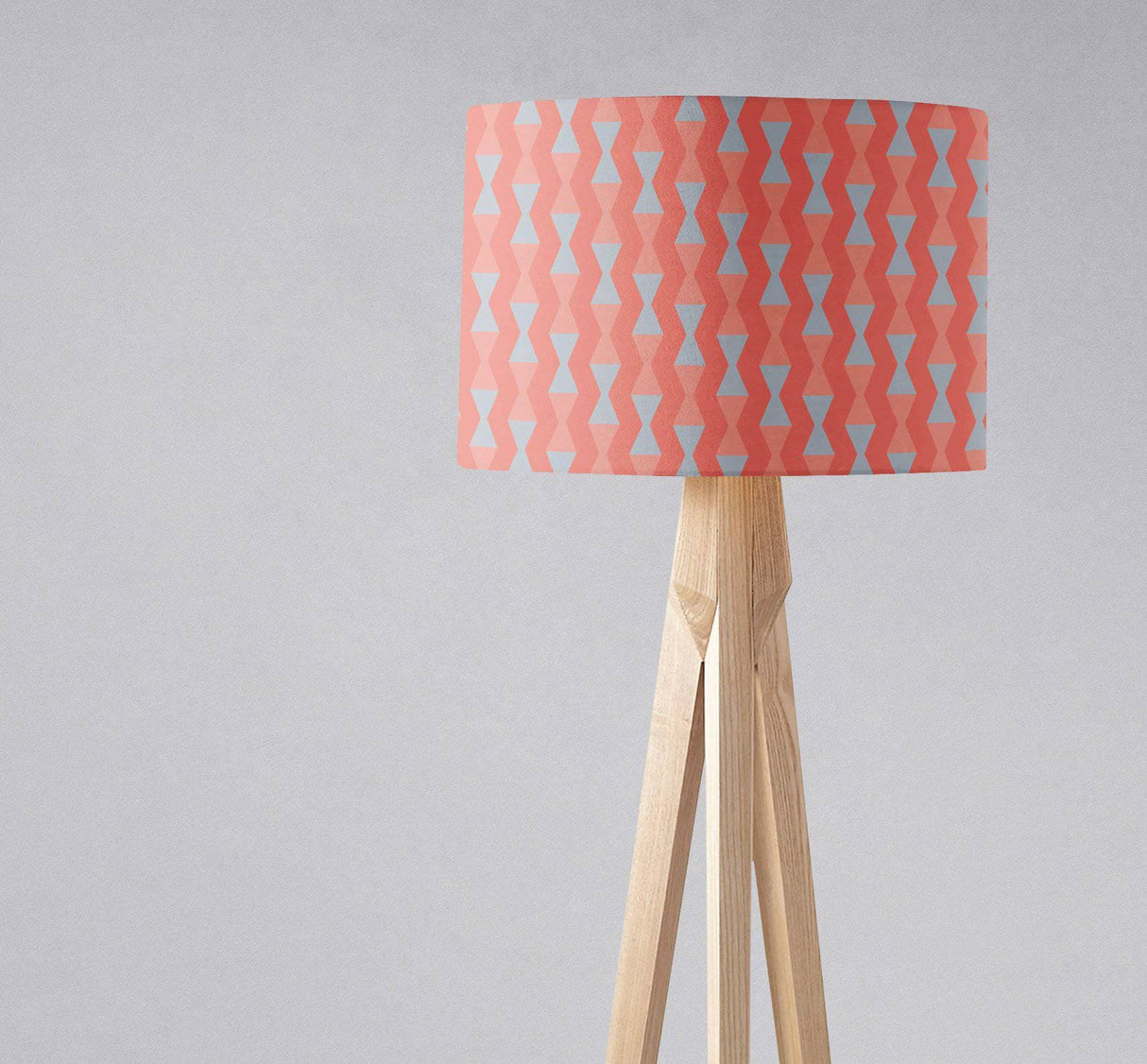 Geometric pattern lampshade by Shadow Bright in pink and blue on a wooden tripod lamp
