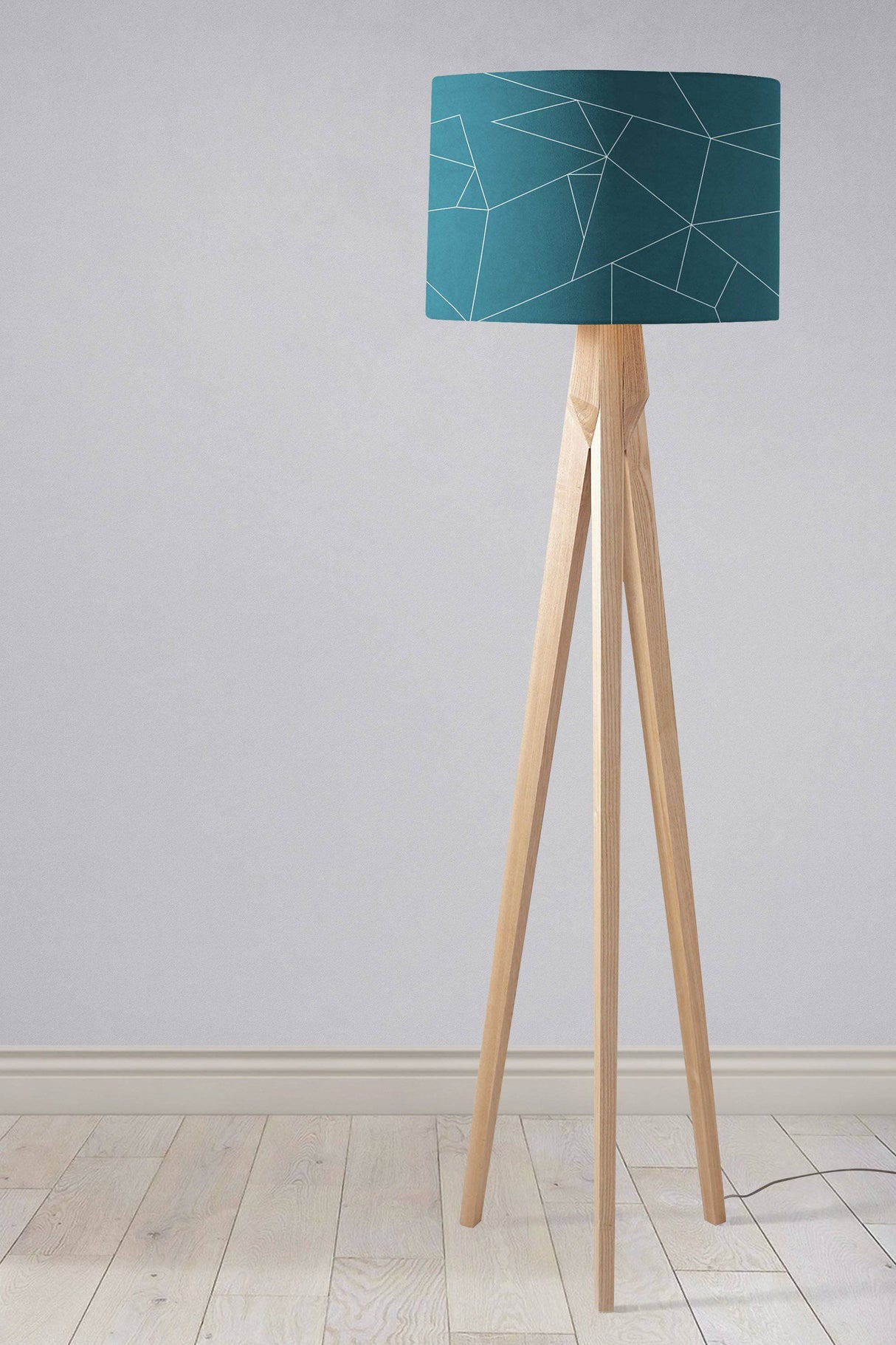 Stylish teal lampshade on a wooden tripod floor lamp, perfect for modern decor