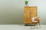 Stylish Orsina Leather Chair with a quilted design next to a wooden storage cabinet
