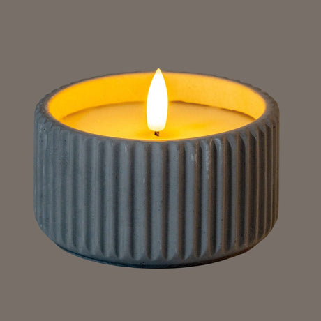 Shades 4 Seasons LED Candle in a textured grey holder with a soft glowing flame