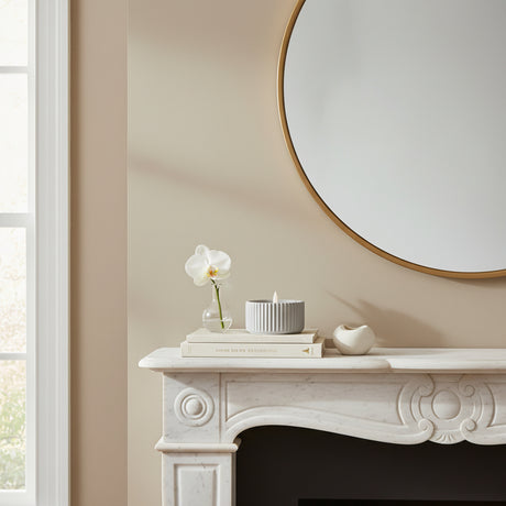 Elegant led candle on a marble mantelpiece with a circular mirror in a bright living room